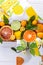 Mix of fresh citrus fruits with green leaves in basket. Orange, lemon, mandarin, lime, kumquat on white background