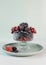 A mix of frozen berries in a transparent bowl. Berries are rich in vitamin C, home freezing, harvesting for the winter.