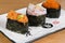 Mix of gunkan with salmon and avocado tartare, shrimp meat and lemon peel and caviar wrapped in nori seaweed