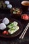 Mix of Japanese food - rice balls onigiri, omelette, ginger, sunomono wakame cucumber salad. Traditional dessert of bean and green