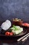 Mix of Japanese food - rice balls onigiri, omelette, pickled ginger, sunomono wakame cucumber salad and chopsticks. Asian