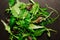 Mix of lettuce leaves different types on black table.