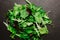 Mix of lettuce leaves different types on black table.