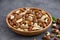 Mix of nuts in a wooden bowl on a dark concrete background. Healthy food concept. Horizontal, selective focus
