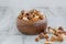 Mix of nuts in a wooden bowl on a light wooden background. Healthy food concept. Horizontal, selective focus