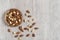 Mixed almonds in a bowl on a wooden background.