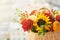 Mixed autumn flowers in basket, bouquet is on the windowsill with copy space.