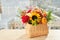 Mixed autumn flowers in basket, bouquet is on the windowsill with copy space.