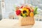 Mixed autumn flowers in basket, bouquet is on the windowsill with copy space.