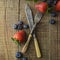 Mixed berries, blueberry, strawberry on wood background with vintage, styled fork and knife. Styled food, fruit background.