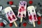 Mixed berry yogurt popsicles on a slate background