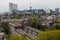 Mixed classic architecture of Rotterdam leafy urban apartment buildings in foreground with modern city high rise, tall towers and