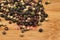 Mixed colorful peppercorn on the wooden board.