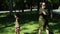 Mixed family - white woman and her black daughter doing simple warming up exercises in the green park