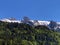 Mixed forests and snowy alpine peaks over the valley of Wagital or Waegital and artificial mountain lake Wagitalersee