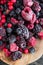 Mixed frozen berries on wooden background