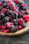 Mixed frozen berries on wooden background