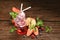 Mixed fruit juice with syrup and soda surrounded by fruits on wooden table