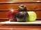 Mixed fruits apples plum mangosteen on plate against wooden background