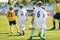 A mixed-gender soccer team playing a football match. Junior soccer tournament game