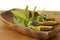 Mixed herbs with scissors in a wooden bowl with sage, thyme, mint and bay leaves.