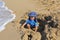 Mixed little toddler boy playing in sand on beach by sea