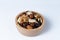 Mixed nut and raisin snack in wooden bowl, isolate background