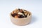 Mixed nut and raisin snack in wooden bowl, isolate background