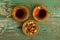 Mixed nuts on a metal saucer and two glass cups of Turkish tea on a turquoise wooden background, top view.