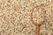 Mixed quinoa seeds with spoon as background, top view