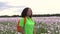 Mixed race African American girl teenager female young woman hiking through field of pink poppy flowers