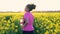 Mixed race African American girl teenager female young woman running and drinking water in field of yellow flowers