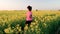 Mixed race African American girl teenager female young woman running or jogging and drinking a bottle of water in field of yellow