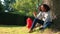 Mixed race African American girl teenager using phone by a tree