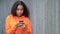 Mixed race African American girl teenager young woman using her smartphone or cell phone for social media