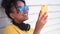 Mixed race African American girl young woman wearing sunglasses using cell phone for social media