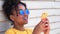 Mixed race African American girl young woman wearing sunglasses using her cell phone for social media