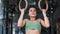 Mixed race athletic woman pull up on wooden gymnastics rings. Medium close up shot on 4k RED camera