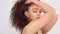 Mixed race black woman with freckles and curly hair in studio on white poses to a camera