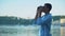 Mixed-race boy looking through binoculars at boats on river, teenager dreams