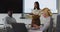 Mixed race businesswoman giving presentation to diverse group of colleagues in meeting room