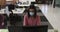 Mixed race businesswoman wearing face mask sitting at desk using computer