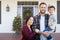 Mixed Race Chinese and Caucasian Parents with Child On Christmas Decorated Front Porch