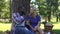 Mixed race couple eating grapes in park and speaking, spending time together