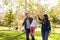 Mixed race couple lifting up their young daughter in park