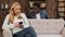 Mixed race couple sitting on a couch while husband is trying to peep into wife\'s mobile phone as she is typing a text