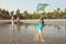 Mixed race family walking with child on sea at sunset