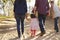 Mixed race family walking on a rural path, back view, crop