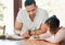 Mixed race father helping his daughter with her homework. Dad teaching daughter to read and write during homeschool