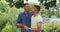 Mixed race gay male couple standing in garden drinking cups of coffee talking and laughing